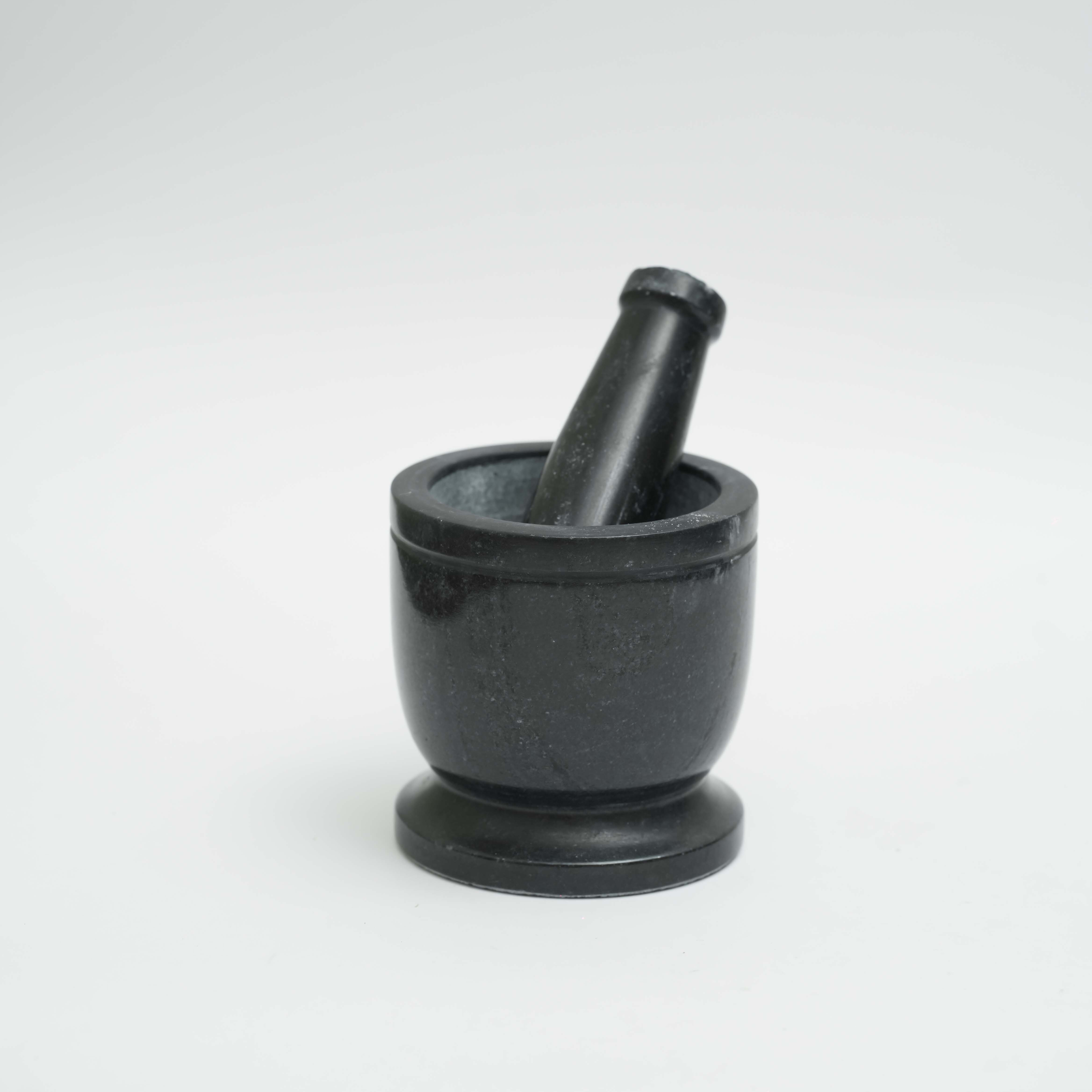 Black marble mortar and pestle on a white background