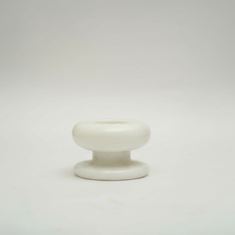 Front view of a handcrafted white marble pedestal ashtray on a clean white background